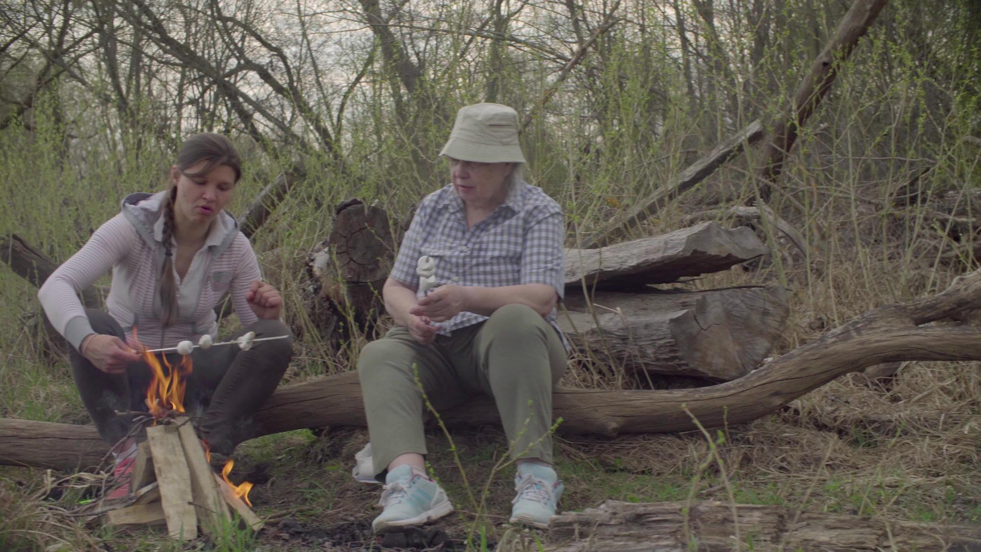 两个女人在火上烤棉花糖视频的预览图