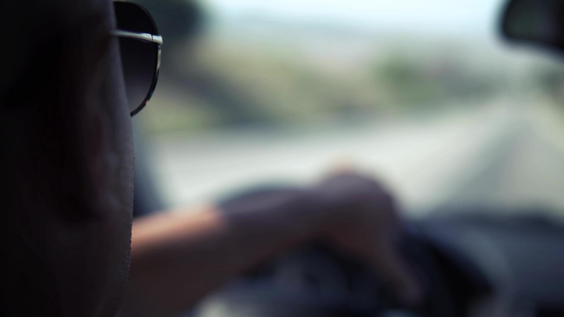 戴着太阳镜的人在路上开车视频的预览图