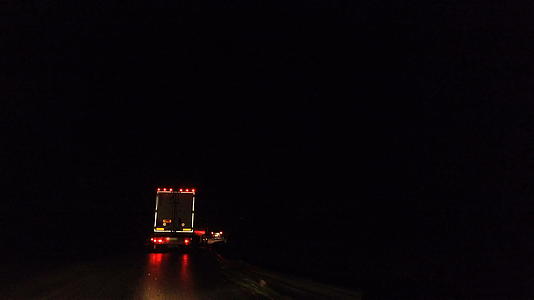 一半的卡车中潮湿的夜路视频的预览图