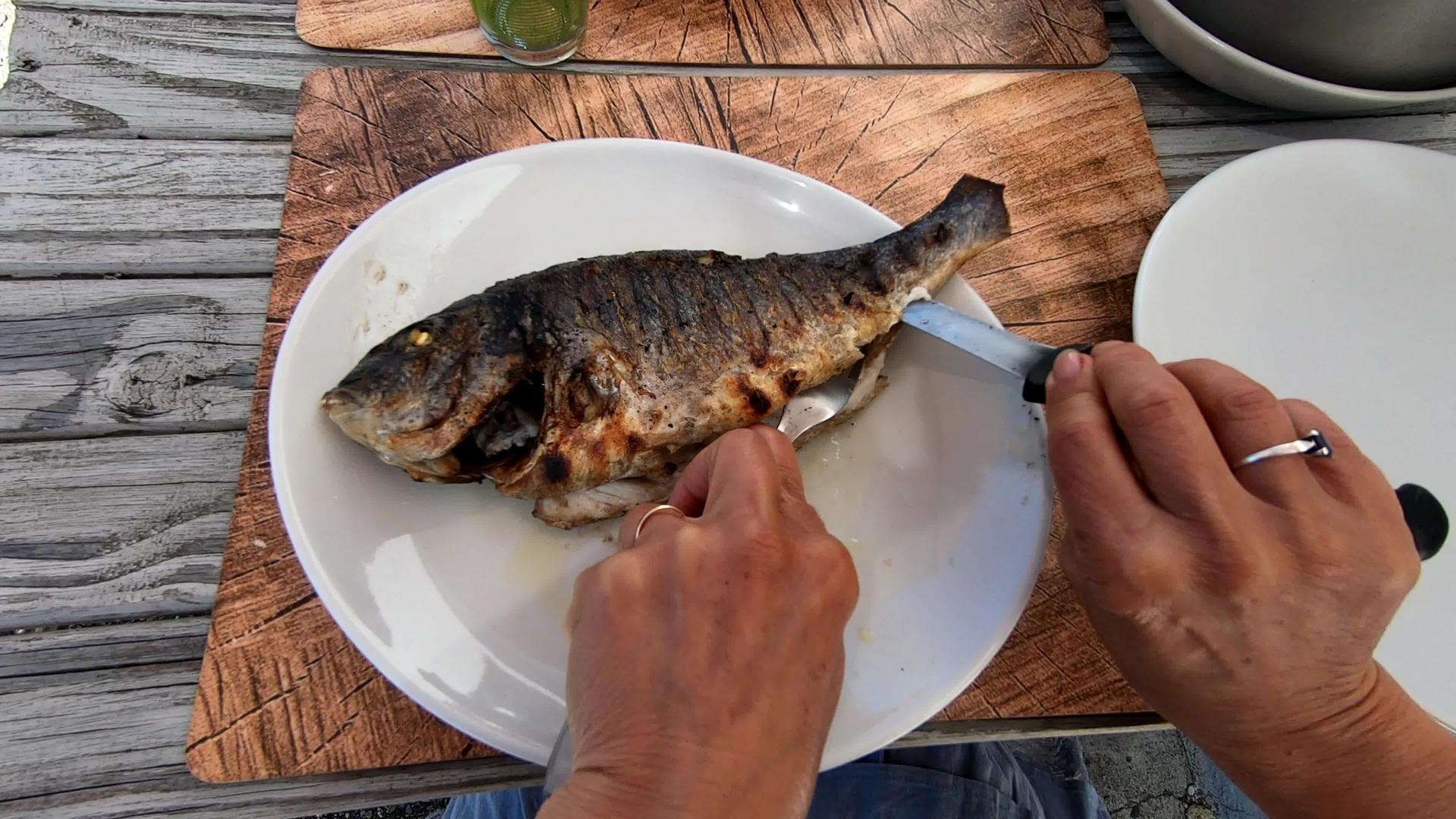 女性用手切鱼盘上美味的鱼视频的预览图