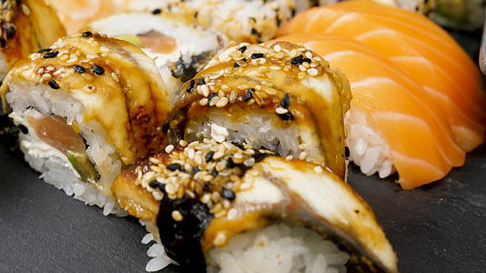 各种混合寿司卷在黑石板上视频的预览图