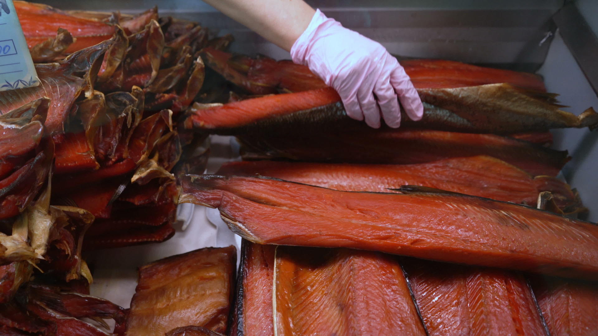 在鱼市柜台展示熏咸红鲑鱼的近手视频的预览图