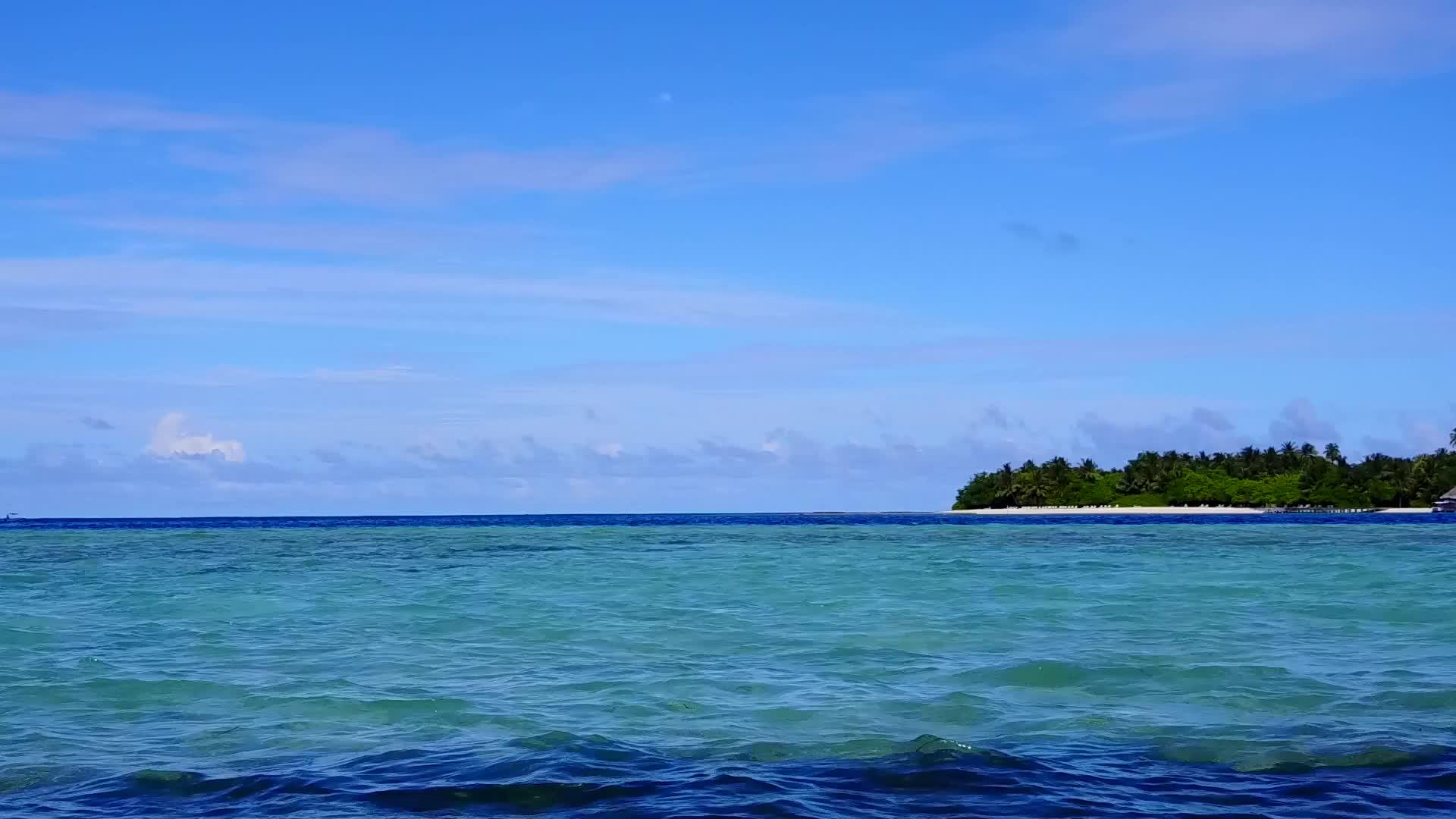 以蓝海和白色沙底蓝海作为休平湾海滩度假的全天全景飞行视频的预览图