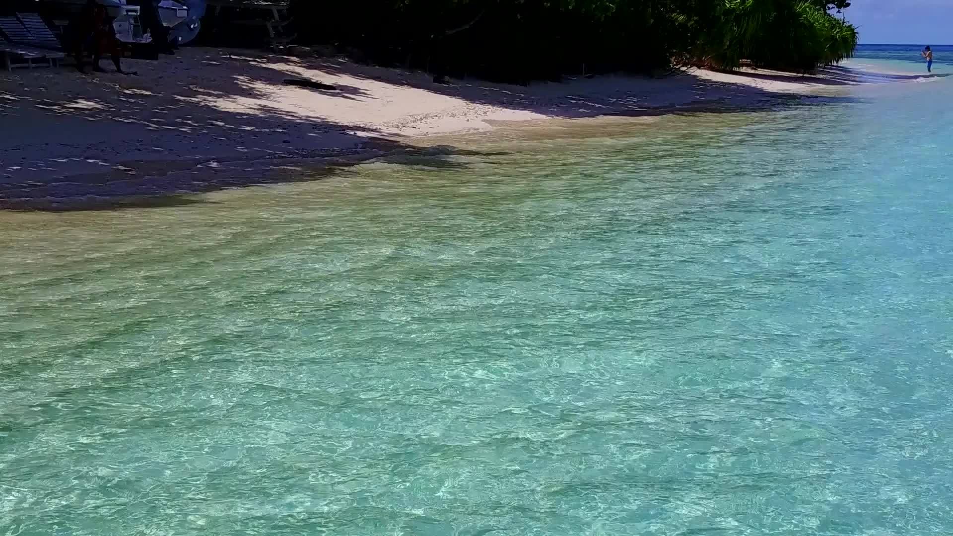 以清水和白色沙底为背景的清水是一个长长的海岸线海滩假日空中视频的预览图