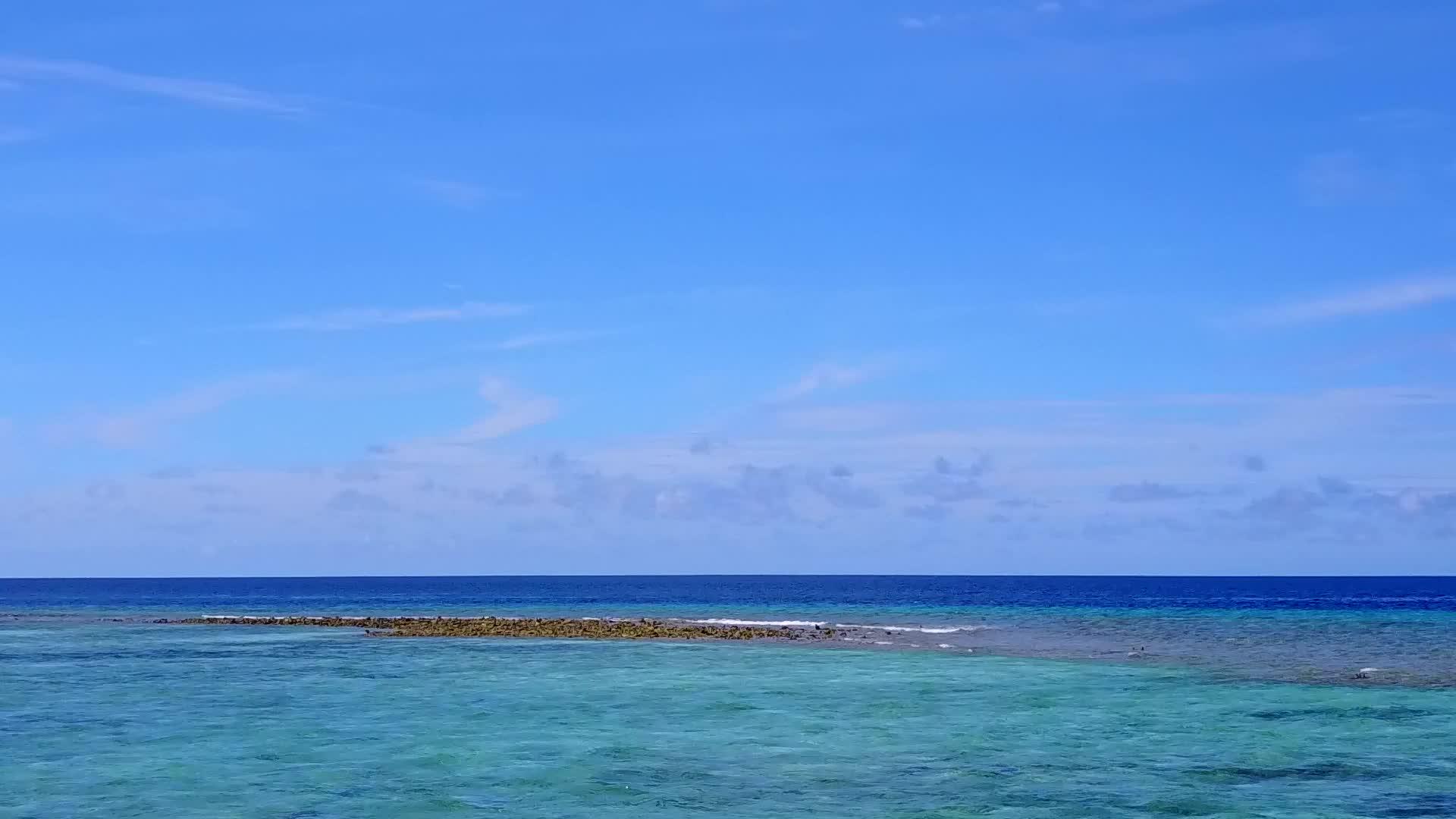 干净的沙质背景美丽的蓝海度假村海滩度假空中无人机视频的预览图