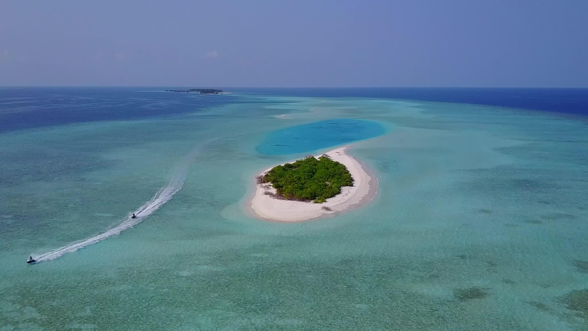 以蓝绿色泻湖和白沙为背景的豪华海岸海滩度假无人机旅游视频的预览图