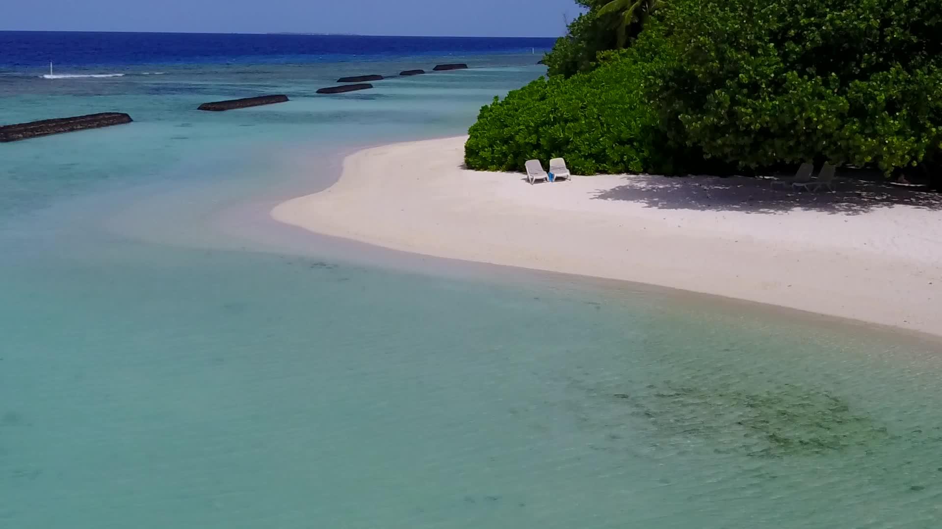 以蓝色水和白色沙土为背景的美丽环礁湖海滩视频的预览图