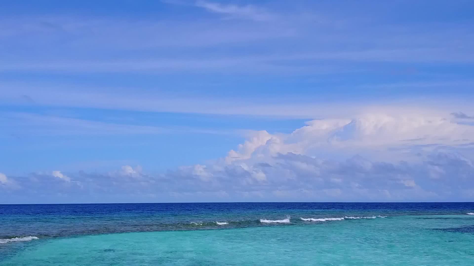 浅海和白沙的背景打破了热带海岸海滩的无人机天空视频的预览图