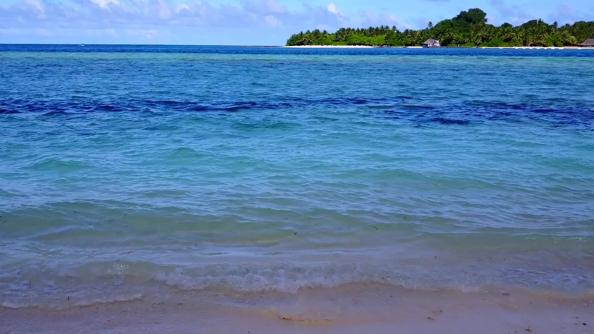 通过透明水和浅沙背景的透明水放松海岸线海滩假日的空气视频的预览图