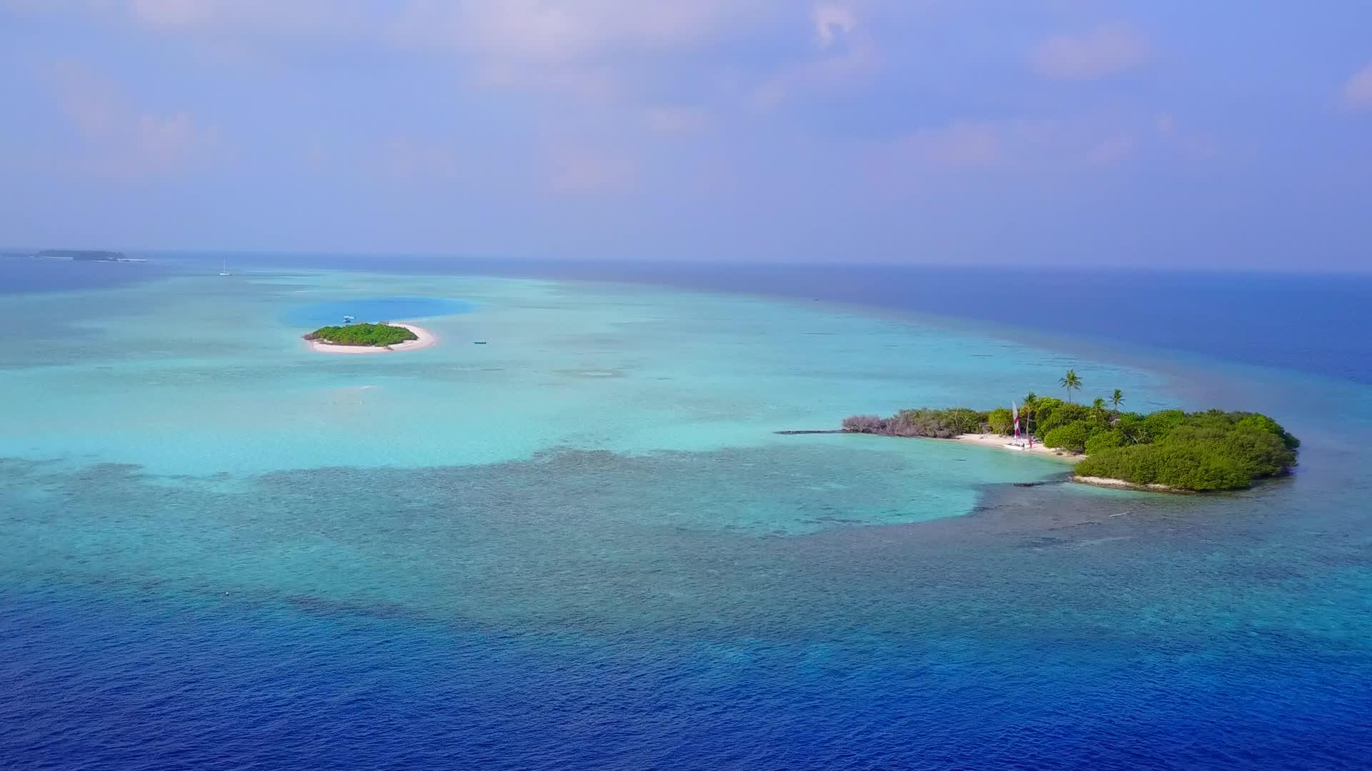 热带环礁海滩以蓝绿色环礁湖和白色沙滩为背景视频的预览图