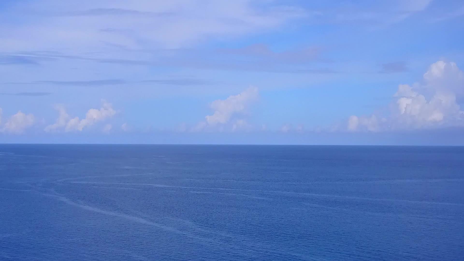 以蓝海和白沙为背景的安静岛屿海滩航程的空中观察性质视频的预览图