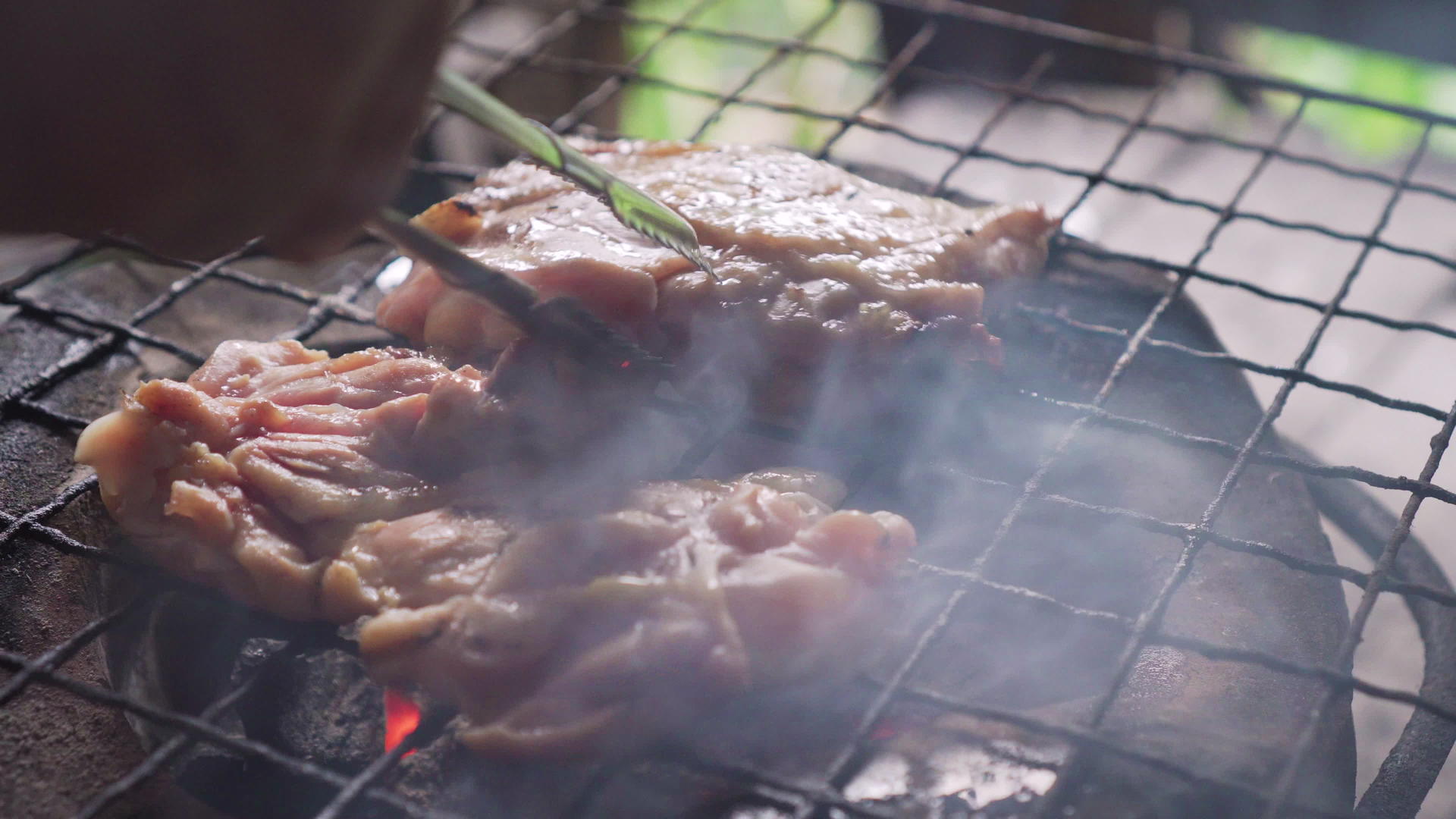 传统的炉子上烤着鸡的大腿里面充满了热火和烟雾视频的预览图