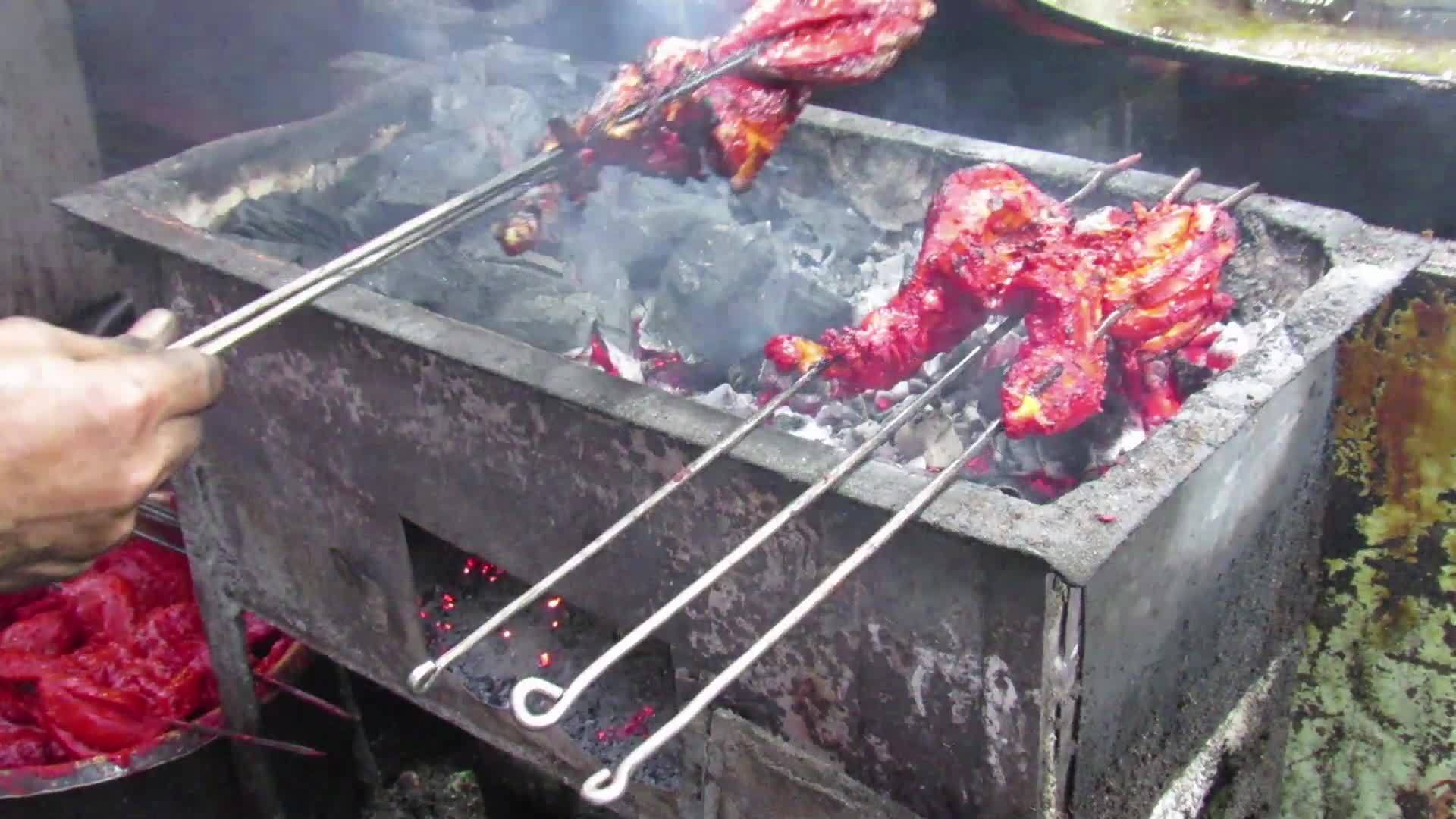在烤架上用煤和其他天然调味剂烤鸡的电动足迹Liftar视频的预览图