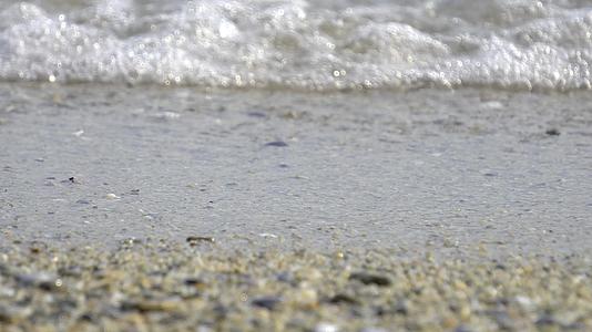 观察在一个失去焦点的海滩上有溅水波视频的预览图