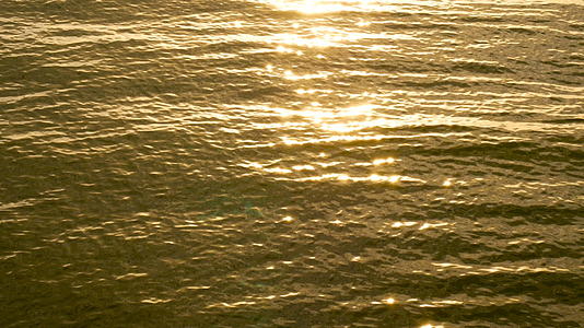 4K在热带海滩上惊人的日落中海滩上的海浪反射了太阳视频的预览图