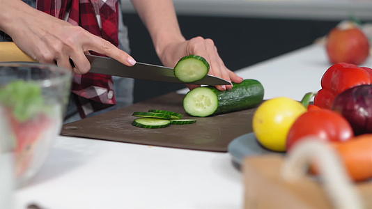 从低角度在桌子上切黄瓜用温和的手站在厨房里餐或晚餐视频的预览图