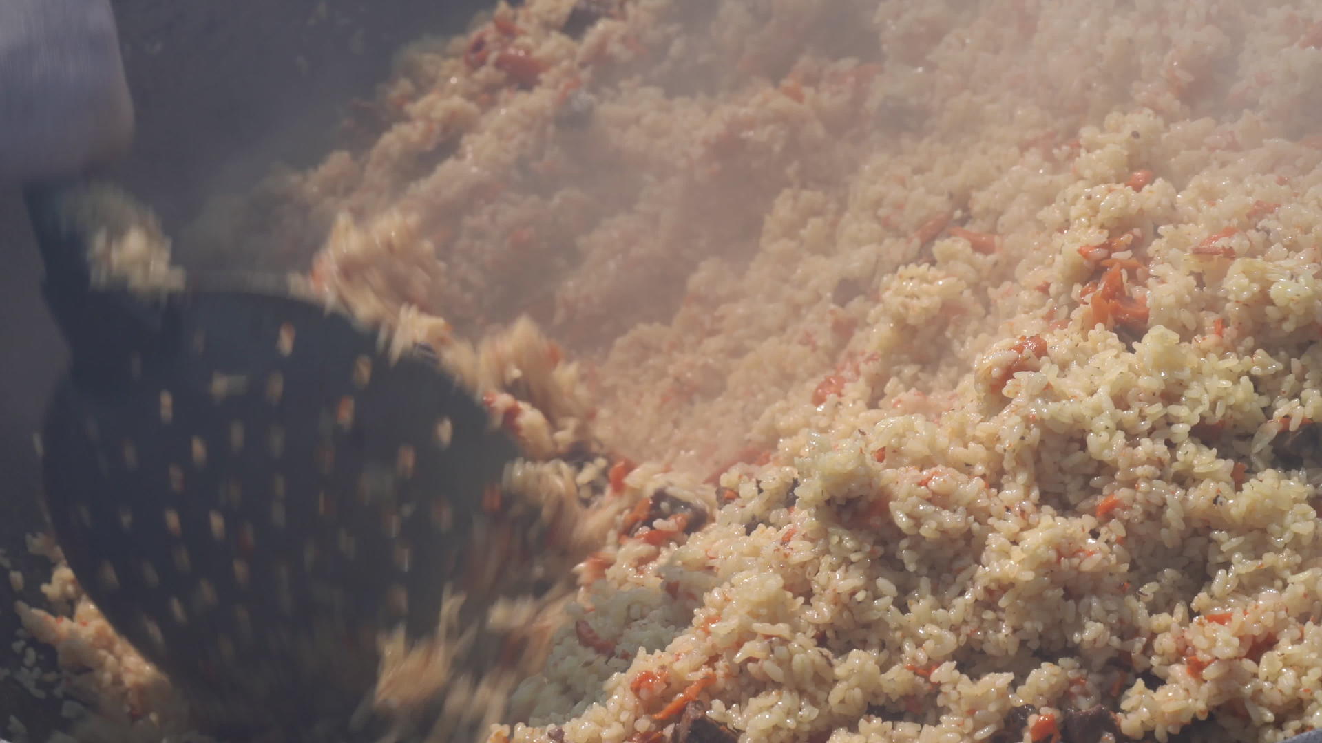 亚洲传统烹饪在大锅里用米饭和厨房勺子煮肉视频的预览图