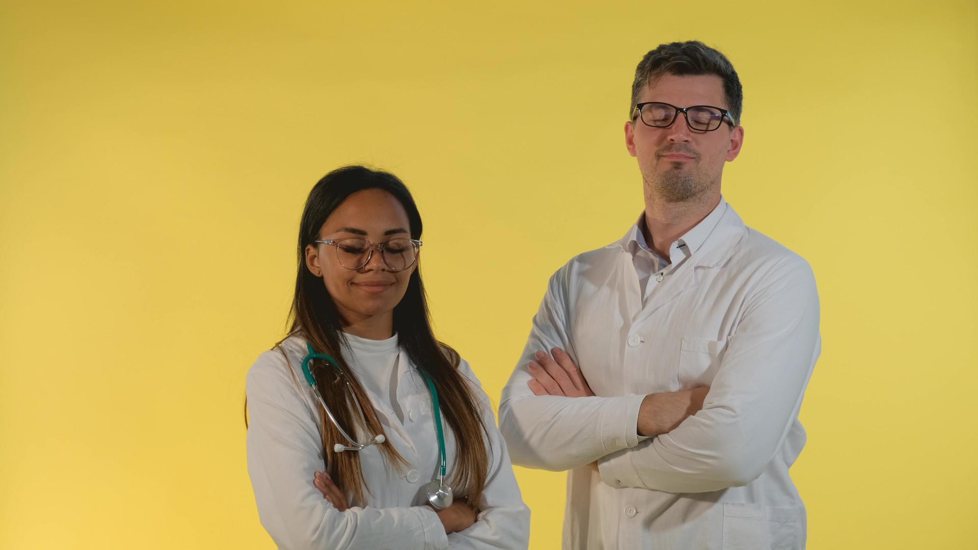 多种族的男医生和女医生用黄色背景照亮他们的头视频的预览图