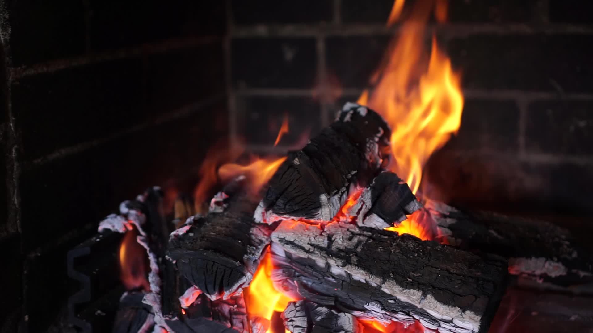 在砖壁炉中燃烧的橡木柴在平坦的背景下稳定关闭视频的预览图