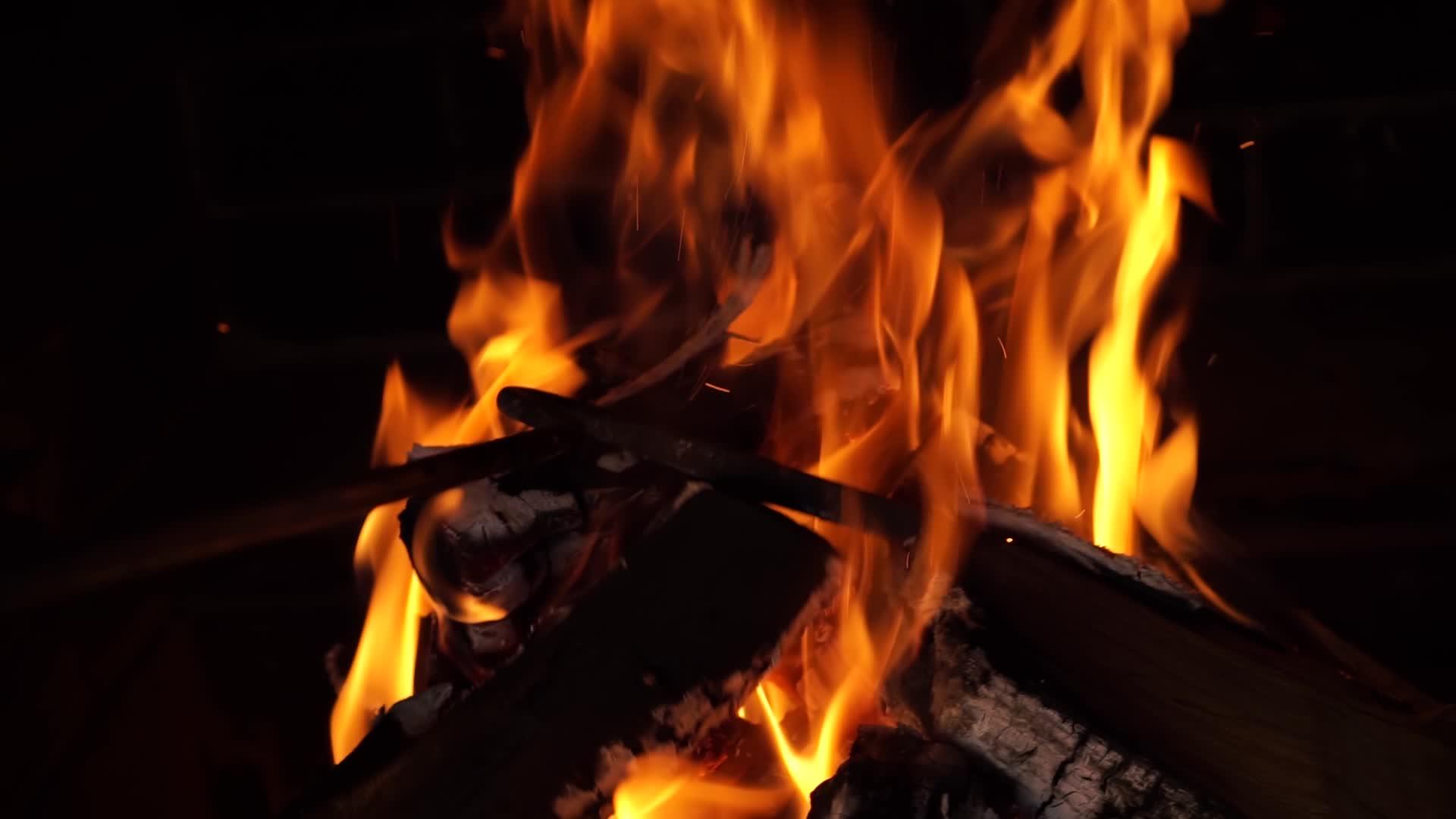 火铁扑克推动和移动燃烧的橡木、柴火、热火花颗粒在深色背景下视频的预览图