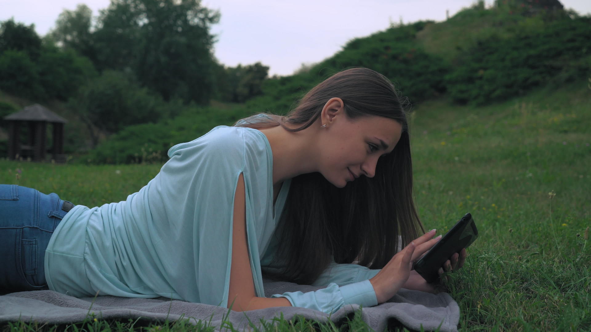 女孩躺在公园的草坪和石头上视频的预览图