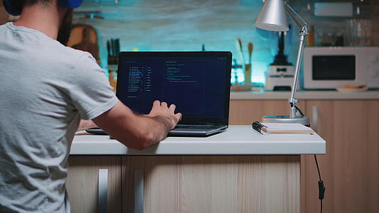 男性黑客在键盘上打字时戴头盔在家工作视频的预览图