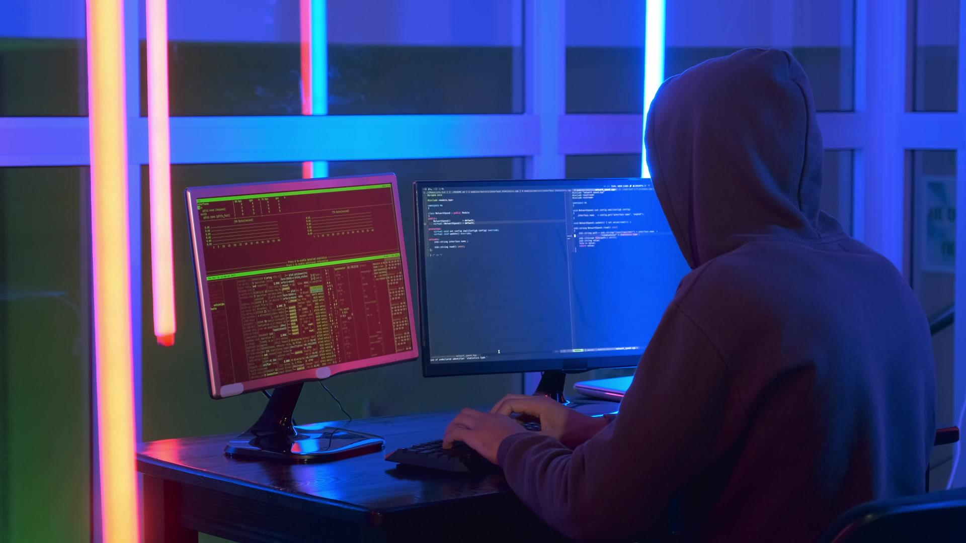 黑客穿着深黑色的中镜头在电脑上工作视频的预览图