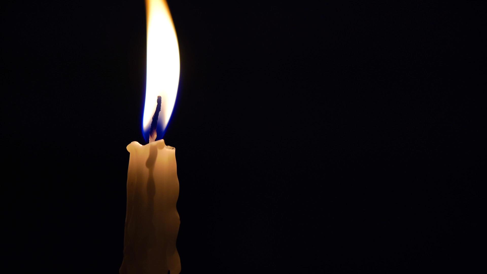 在黑暗中点燃蜡烛在黑色背景上点燃蜡烛视频的预览图