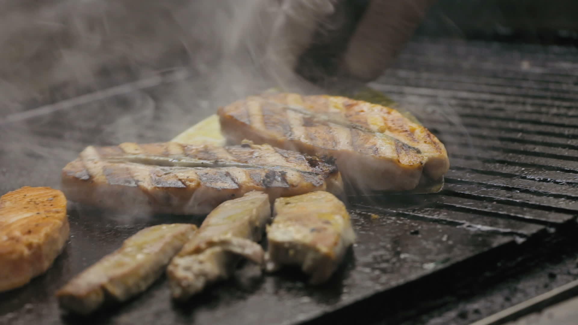 厨师在烤架上煮肉和鱼视频的预览图