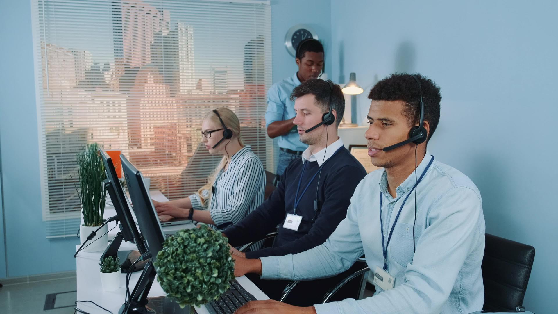 黑色电话接线员帮助同事在呼叫中心工作视频的预览图