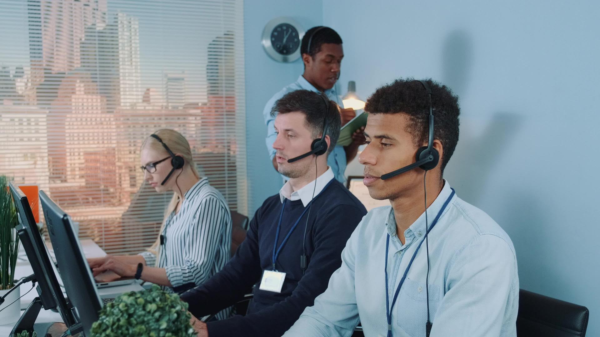 男性经理接线员在呼叫中心帮助同事视频的预览图