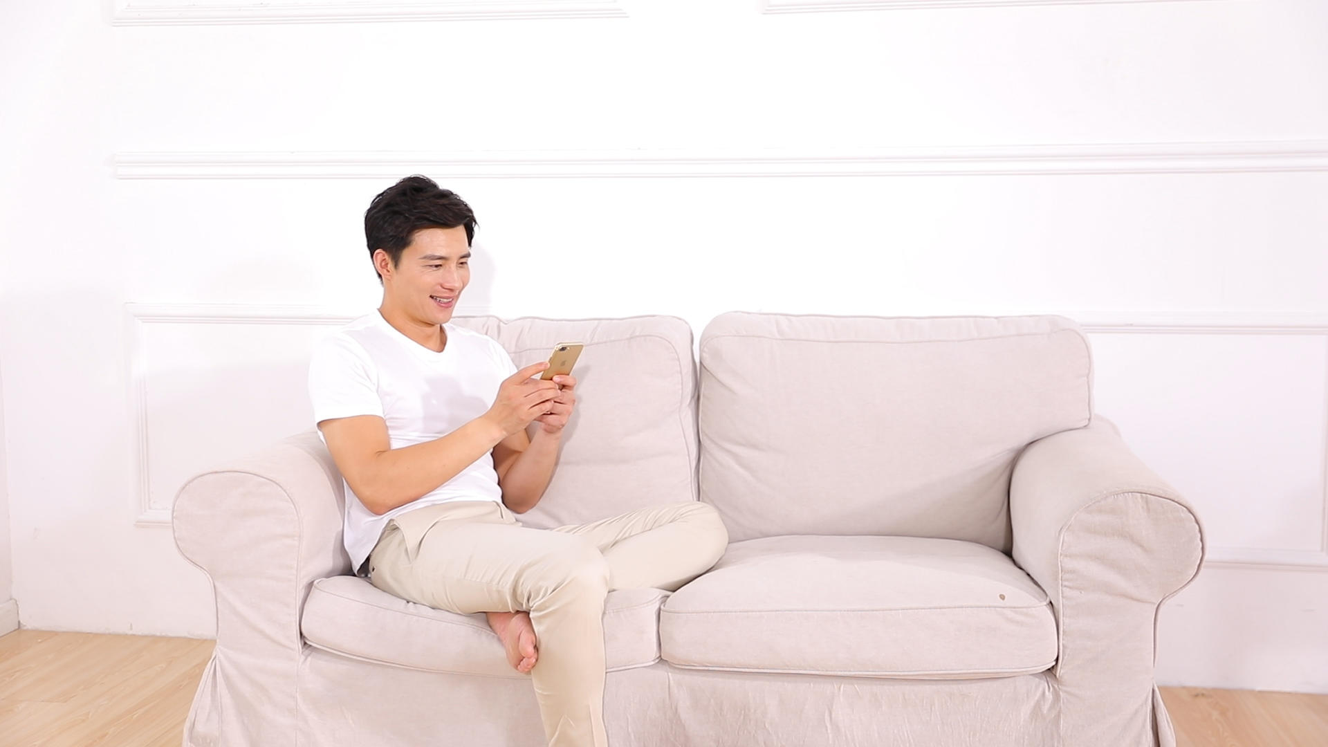 居家男青年在沙发上使用手机视频的预览图