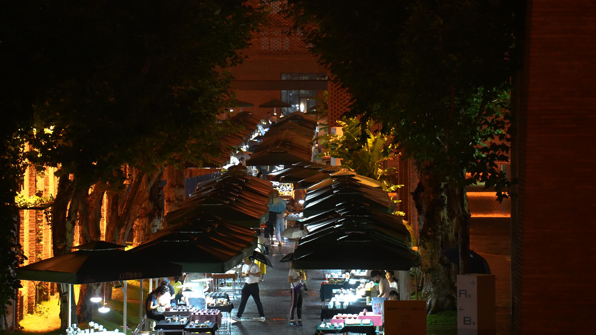 城市雨天夜晚打着伞集市逛街的行人4k素材视频的预览图
