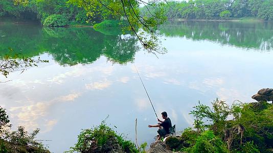田园间夕阳下波光粼粼湖面钓鱼的人视频的预览图