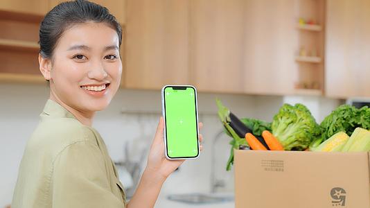 女人居家用手机下单买菜展示手机视频的预览图
