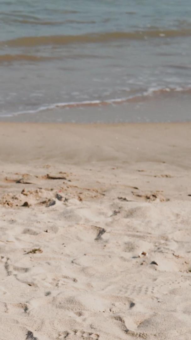 海滩上手持太阳帽特写海浪涨潮视频的预览图