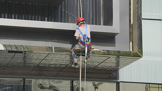 城市物业保洁工作人员吊安全绳清洁外墙劳动4k素材视频的预览图
