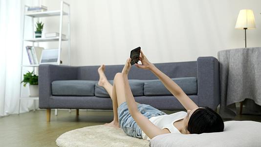 躺在地毯上玩手机的女生视频的预览图