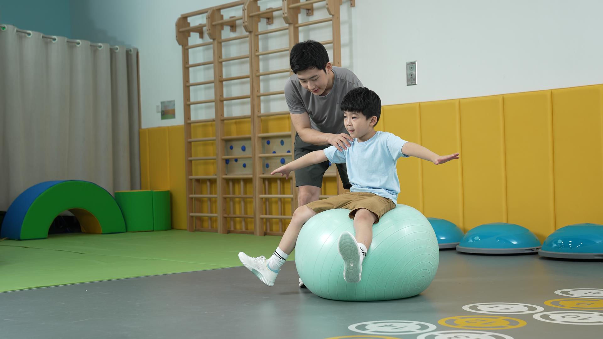 男孩坐在瑜伽球上锻炼平衡能力视频的预览图
