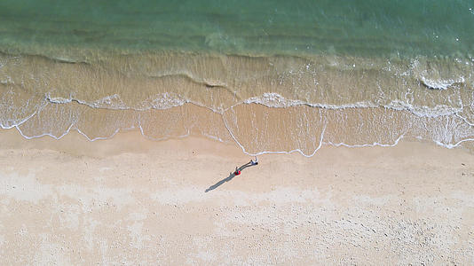 航拍城市海边海景沙滩上散步的人4k素材视频的预览图
