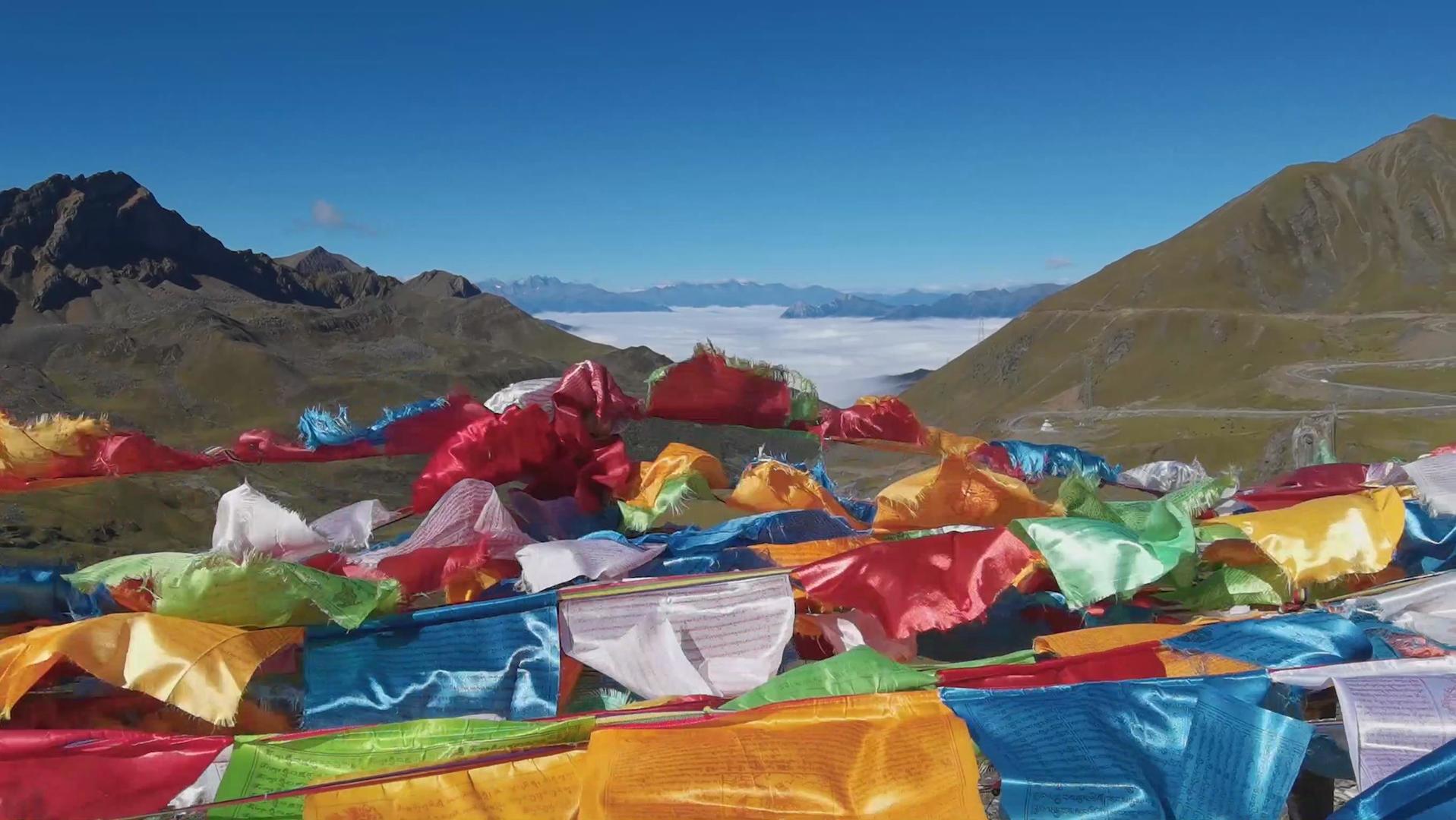4K藏地高山垭口大风天气随风起舞的经幡以及远处的云海和雪山视频的预览图