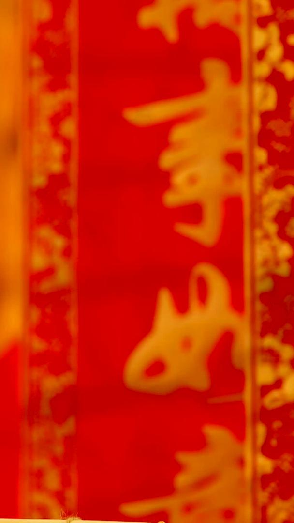 红色喜庆背景前悬挂红包福字礼盒从上到下拍摄静物视频视频的预览图