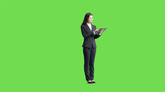 4k穿西服的女生使用平板电脑上网绿幕抠像视频视频的预览图