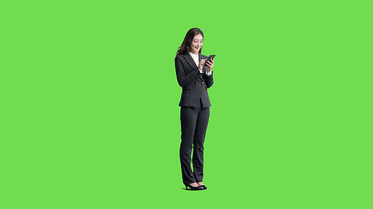 4k穿西装的女生使用手机自拍全身绿幕抠像视频视频的预览图