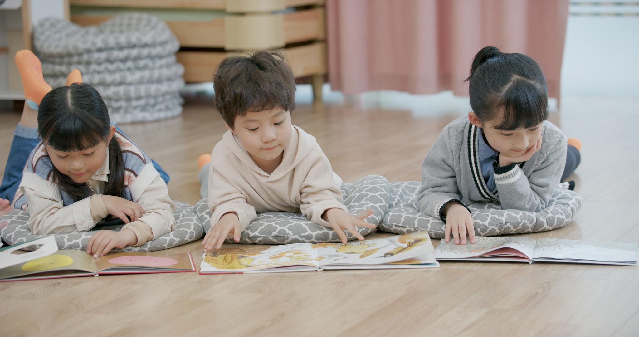 8K幼儿园小朋友们趴在地上看故事书视频的预览图