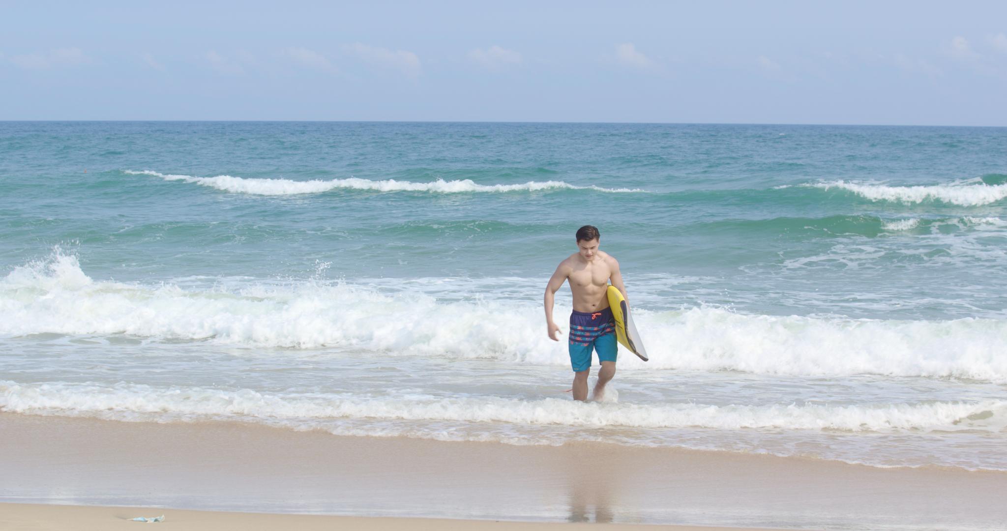 8K男青年海边抱着冲浪板视频的预览图