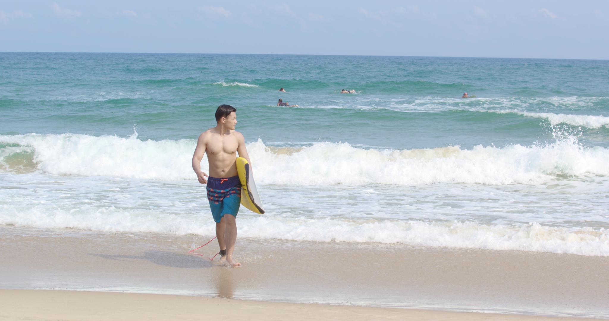 8K海边抱着冲浪板的男青年视频的预览图