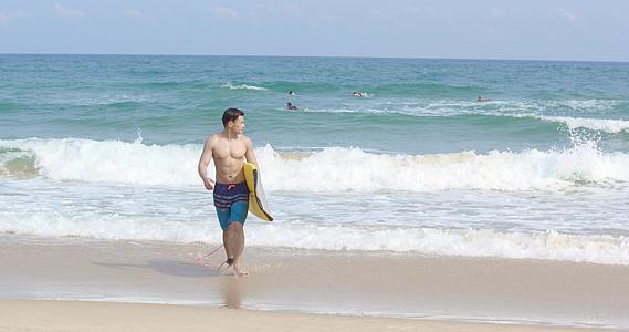 8K海边抱着冲浪板的男青年视频的预览图