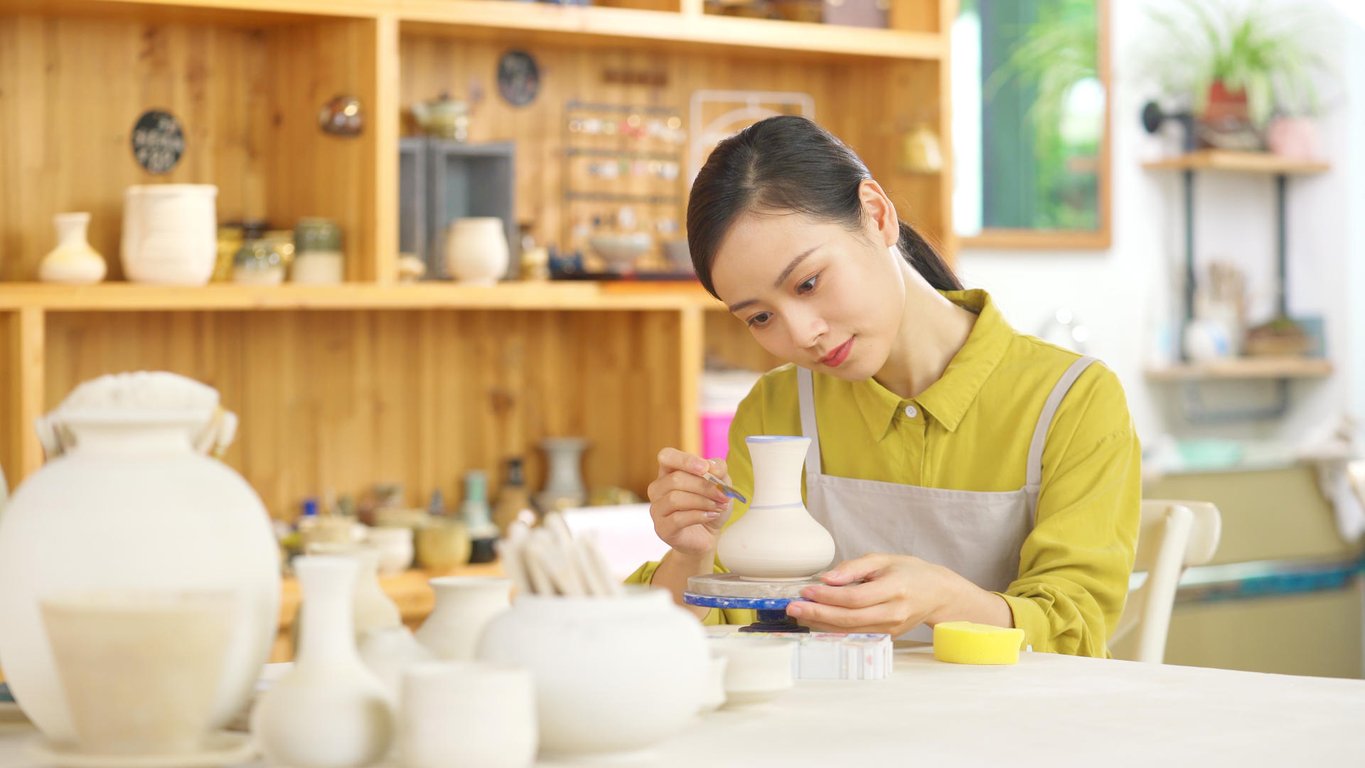4k陶器店陶艺DIY女生正在给陶器陶罐上色视频的预览图