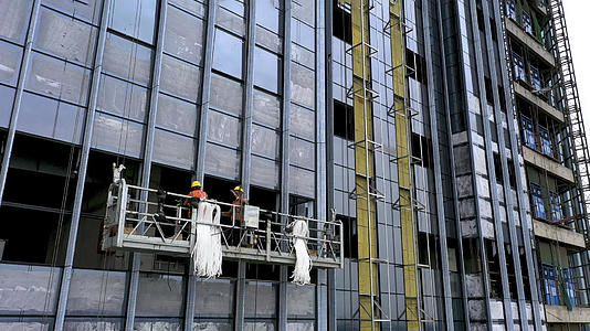 4K航拍大楼玻璃幕墙施工的工人视频的预览图
